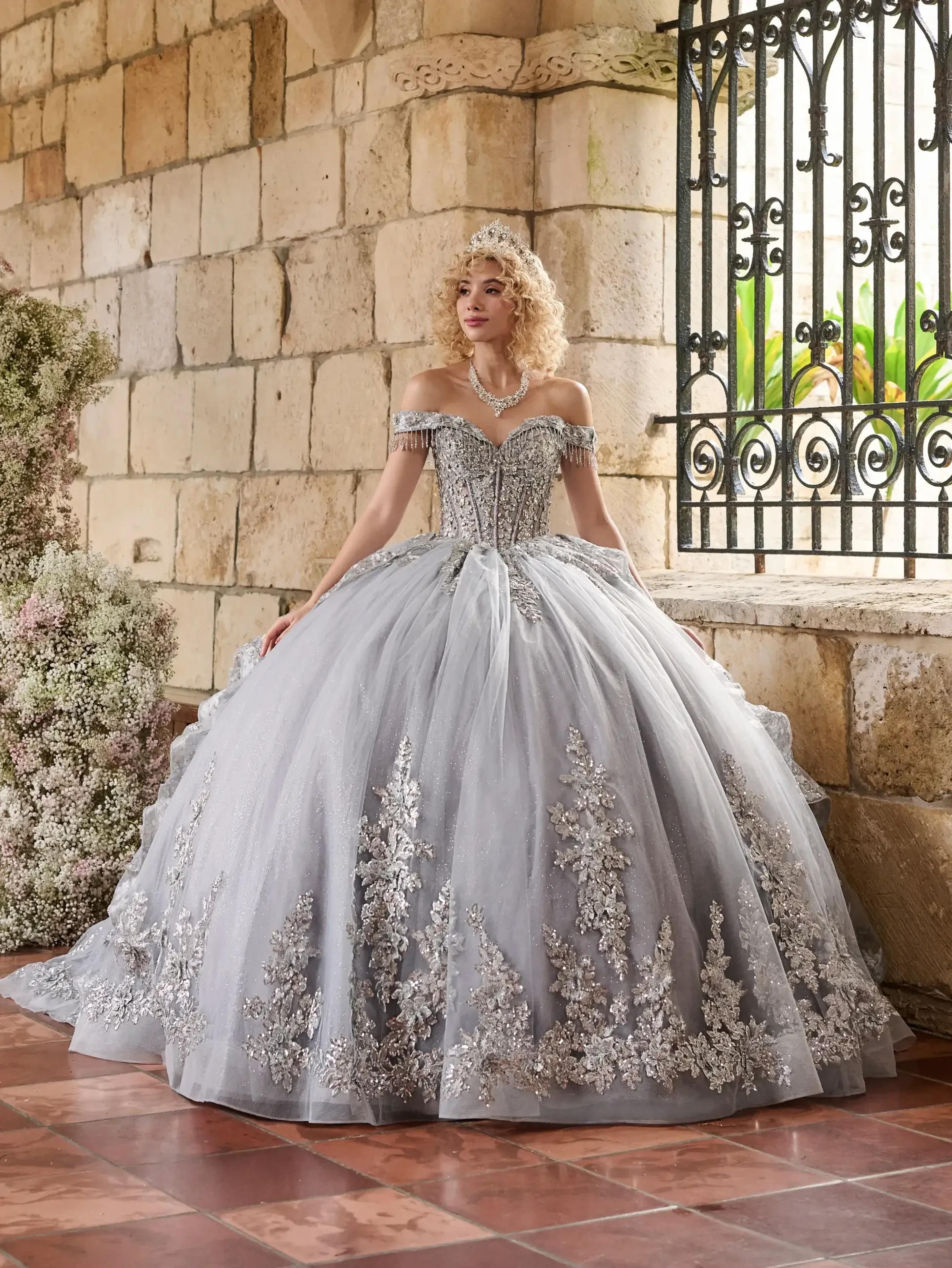 model is wearing a grey off the shoulder ball gown quince dress