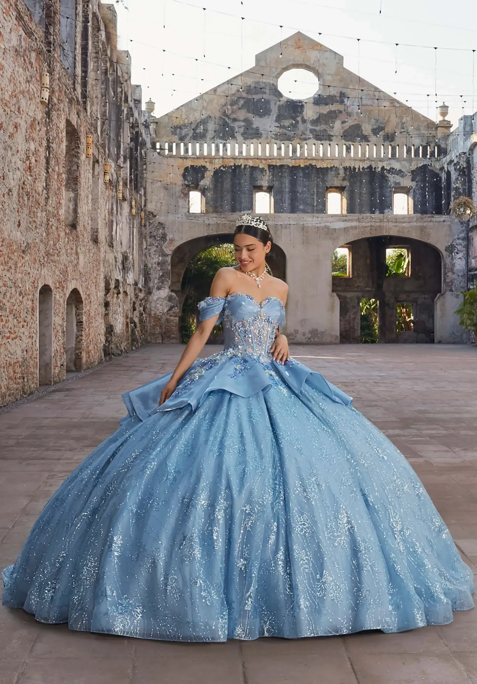 model is wearing a dusty blue quinceanera dress